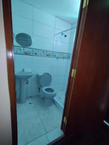 a bathroom with a toilet and a sink at Inti Ut'ha in Puno