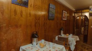 a dining room with two tables and chairs and wooden walls at Rama Inn Hostal in Puno