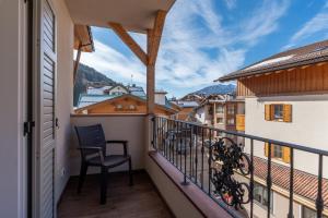 een balkon met een stoel en uitzicht bij Hotel Meida in Pozza di Fassa