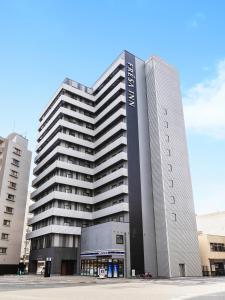 un edificio alto con un cartel en la parte delantera en Sotetsu Fresa Inn Hiroshima, en Hiroshima