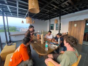 eine Gruppe von Menschen, die in einem Restaurant an einem Tisch sitzen in der Unterkunft Madpackers Jaipur in Jaipur