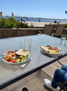 dos platos de comida en una mesa en la playa en Beach Front Bungalow At Pacific Beach, en San Diego