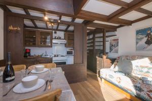 una cucina e un soggiorno con tavolo e divano di Résidence Grand Roc - Campanules 415 - Happy Rentals a Chamonix-Mont-Blanc