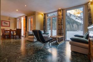 Chalet Glacier - Happy Rentals في شامونيه مون بلان: غرفة معيشة مع طاولة وكراسي ونافذة كبيرة