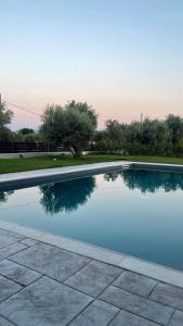 a swimming pool with the reflection of trees in the water at Nostos Luxury Villas with Private Pool in Nafpaktos in Nafpaktos