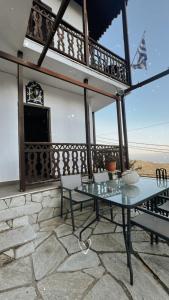 a patio with a table and chairs on a balcony at Pilioritiko Spiti in Makrinítsa