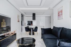 a living room with a black couch and a table at Platinum Towers J&K in Warsaw