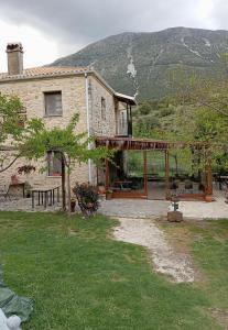 ein Steinhaus mit einem Tisch und einer Terrasse in der Unterkunft XENONAS SOULIOU in Samonída