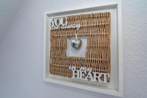 a picture of a heart in a picture frame on a wall at Möwennest App 18 in Wenningstedt