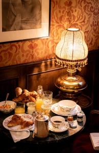 een tafel met borden en een lamp bij Hotel Flora in Venetië