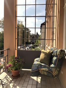 d'un canapé installé sur un balcon avec une grande fenêtre. dans l'établissement Hotel Villa Hentzel, à Weimar