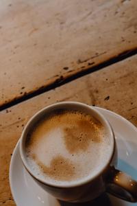 eine Tasse Kaffee auf einem Teller auf einem Tisch in der Unterkunft Apartmentresort MyLodge in Schladming