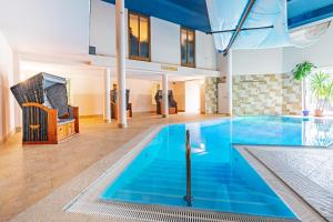 ein großer Pool mit blauem Wasser in einem Gebäude in der Unterkunft SEETELHOTEL Nautic Usedom Hotel & Spa in Ostseebad Koserow