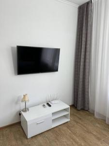 ヴィーンヌィツャにあるApartment For Guests with Soulの白いキャビネット(壁に薄型テレビ付)