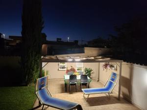 eine Terrasse mit einem Tisch und Stühlen im Hinterhof in der Unterkunft Emotions in Fiumicino