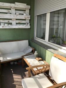 porche con sofá, mesa y ventana en Rózsadomb apartman, en Pécs