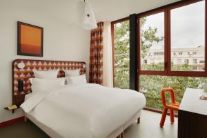 a bedroom with a white bed and a window at Edgar Suites Montrouge in Montrouge