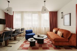 a living room with a couch and a table and chairs at Edgar Suites Montrouge in Montrouge