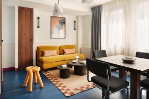 a living room with a yellow couch and a table at Edgar Suites Montrouge in Montrouge