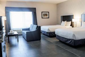 une chambre d'hôtel avec deux lits et une chaise dans l'établissement Park Inn by Radisson Edmonton Airport, à Leduc