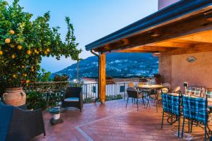 um pátio com uma mesa e cadeiras e uma laranjeira em B&B IL CORTILE em Ravello