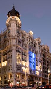 un gran edificio blanco con un cartel azul en Hotel Atlántico, en Madrid