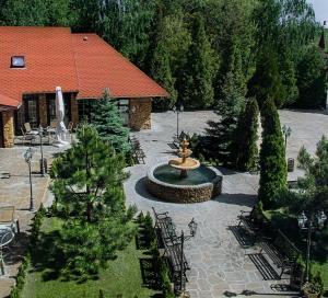 un cortile con fontana e alberi e un edificio di Отель Вышеград a Vyšhorod