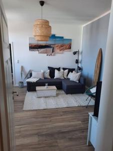 a living room with a blue couch in a room at Apartment mit beach flair in Garz-Rügen