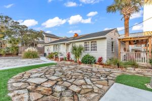 a home with a stone driveway and palm trees at Holiday Shores Myrtle Beach in Myrtle Beach