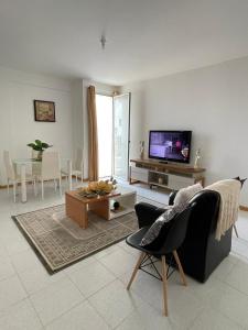 a living room with a couch and a tv at Casa Do Encanto in Praia