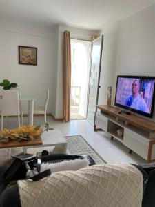 a living room with a flat screen tv on a table at Casa Do Encanto in Praia