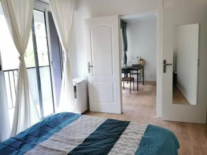 um quarto com uma cama e um quarto com uma mesa em Cosy Apartment at Mérignac-centre em Mérignac