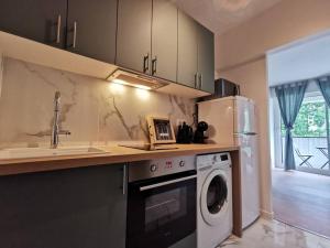 uma cozinha com uma máquina de lavar roupa e um lavatório em Cosy Apartment at Mérignac-centre em Mérignac