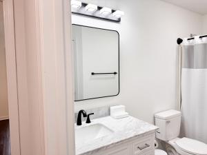 La salle de bains blanche est pourvue d'un lavabo et d'un miroir. dans l'établissement Aesthetic Home Near Ft Campbell, à Clarksville