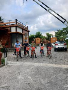 eine Gruppe Männer auf einem Parkplatz auf Fahrrädern in der Unterkunft Tzy-No Family Cottage in Balong