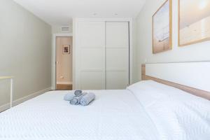 a bedroom with a white bed with towels on it at Acogedor Refugio con Terraza in Alcalá de Henares