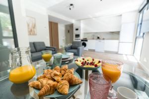 a table topped with plates of pastries and orange juice at Acogedor Refugio con Terraza in Alcalá de Henares