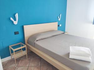 een slaapkamer met een bed en een blauwe muur bij Ristorante Albergo Dante in Montefiascone