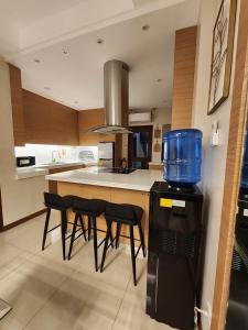 uma cozinha com uma grande ilha com bancos de bar em Gloria Tree Mayon and Park View Residences em Legazpi