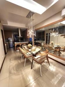 uma sala de jantar com mesas e cadeiras e uma cozinha em Gloria Tree Mayon and Park View Residences em Legazpi