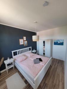 a bedroom with a white bed and a blue wall at Apartment mit beach flair in Garz-Rügen