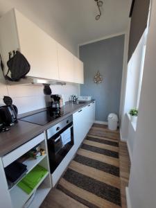 a small kitchen with white cabinets and a stove at Apartment mit beach flair in Garz-Rügen