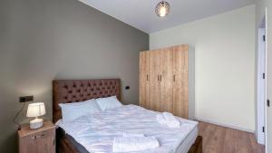 a bedroom with a bed and a wooden cabinet at Tbilisi Vi64 in Tbilisi City