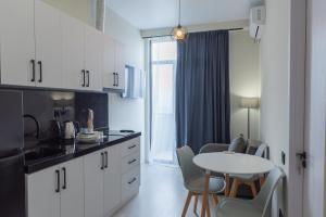 a kitchen with white cabinets and a table and chairs at Tbilisi Vi64 in Tbilisi City