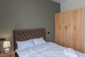 a bedroom with a large bed with a wooden headboard at Tbilisi Vi64 in Tbilisi City