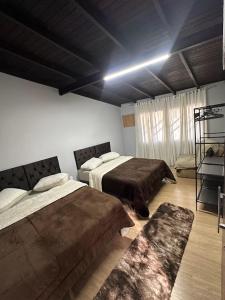 - une chambre avec deux lits et un canapé dans l'établissement Araújo Residence - Lar Doce Lar, à Joinville