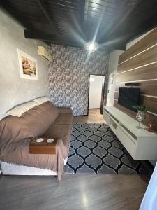 - une chambre avec un lit et une télévision dans l'établissement Araújo Residence - Lar Doce Lar, à Joinville