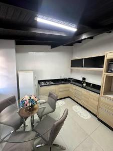 une cuisine avec des chaises et une table. dans l'établissement Araújo Residence - Lar Doce Lar, à Joinville