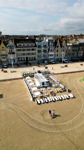 an aerial view of a beach with umbrellas and buildings at Hôtel Merveilleux Côté Mer in Dunkerque