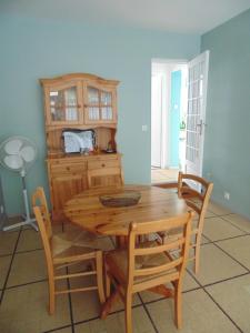 comedor con mesa de madera y sillas en Appartement entièrement rénové avec Wifi tout à pied, en Royan